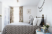 Black and white patterned bedspread in bright bedroom of Faversham home,  Kent,  UK