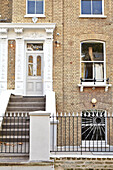 Railings and steps in front of brick London townhouse  England  UK