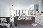 Braune Sofas mit schwarzen und weißen Kissen in einem offenen Londoner Stadthaus England UK