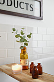 Blätterarrangement und Medizinflaschen auf einem Holzregal im Badezimmer einer Londoner Wohnung UK
