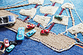 Assorted toy cars on rug with sailing boat in boy's room of London home  UK