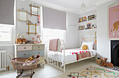Mirrors above upcycled chest with single bed in girl's room of London family home  UK