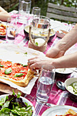 Man serving tomato pastry on table in Sheffield garden  Yorkshire  UK