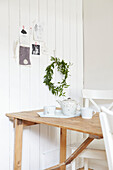 Teapot and cups with wreath on wooden folding table in West Yorkshire kitchen  UK