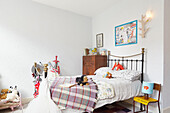 Soft toys on metal framed bed and lamp on chair in Berwick Upon Tweed home  Northumberland  UK