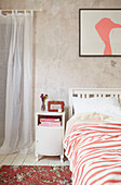 Raumteiler und Schrank neben dem Bett mit gestreifter Bettdecke in einem Haus in Berwick Upon Tweed, Northumberland UK