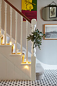 Christmas garland and lit fairylights on banister in London hallway  UK