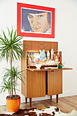 Retro drinks cabinet and pop art with houseplant in East Riding of Yorkshire home  England  UK