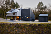 Moderner Neubau mit Sonnenkollektoren in einem Waldgebiet in Devon (UK)