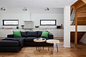 Black corner sofa with bright green cushions in open plan Devon new build  UK