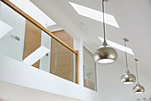 Silver pendant lights and skylights with glass mezzanine in Devon new build  UK