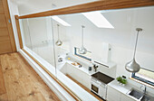 View of kitchen with silver pendant shades from mezzanine in Devon new build  UK