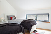 Brown blankets on twin beds at window in Devon new build  UK