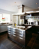 Modern fitted kitchen in stainless steel and slate with central island and extractor hood