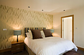 Neutral dekoriertes Schlafzimmer mit Tapete und Nachttischlampen
