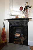 Black painted fireplace with bellows in New Malden home, Surrey, England, UK