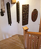 Geschnitzte Stammesschilder im Treppenhaus einer umgebauten Wassermühle