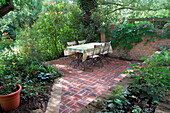 Table and chairs on brick patio in grounds of watermill