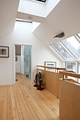 Rocking horse on wooden landing with skylight windows in Essex home UK