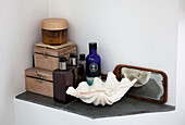Wooden boxes and toiletries with seashell and hand mirror in Essex bathroom UK