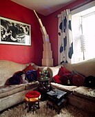 Hocker im afrikanischen Stil im roten Wohnzimmer mit Teppichboden