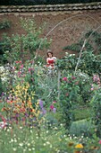 Walled flower garden with young girl
