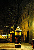 Night in snowy tree lined street 