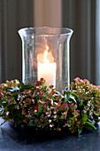 Lit candle with wreath of blossom