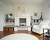 Living room with concrete fireplace slab forming bottom shelf of alcove 