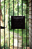 Gate sign on Edwardian brick cottage garden exterior