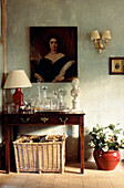 Console table with decanters and female portrait above