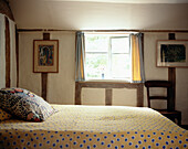 Gefleckte Bettdecke in einem Schlafzimmer im Landhausstil mit niedriger Decke