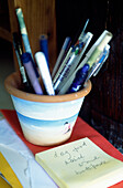 Pens in a pen holder with notepad