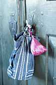 Fabric bags hang from key of wardrobe door