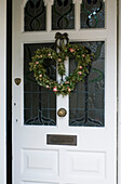 Front door with heart wreath made of ivy and twisted foliage and roses