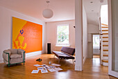 Sofa und Sessel in einer offenen Laminatwohnung mit moderner Kunst