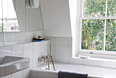 White bathroom and window with mirrored cabinet