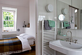 White en suite bathroom and bedroom with checked blanket bed covering