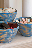 Shell decorations and leather wallets in woven baskets