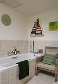 Bathroom with armchair and shelving with books