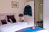Double bed with embroidered bed linen cushions and blankets