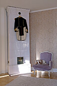 Old-fashioned room with military old uniform hanging on tiled stove