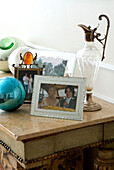 Still life with framed picture and old decorative pitcher