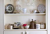 Collection of rustic crockery on kitchen shelf