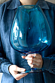 Woman holding blue large glass vase