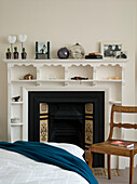 Edwardian fireplace with decorative shelves and tiles in a bedroom