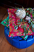 Metallic baubles and eucalyptus on scatter cushions and bright blue pouf