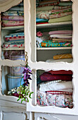 Folded bed linen in storage cupboard