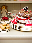 Christmas cake and mince pies with plates on kitchen dresser