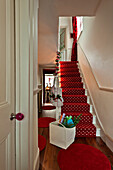 Preparations for Christmas in red carpeted hallway of London home UK